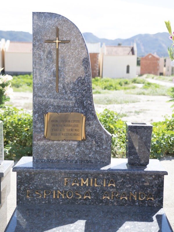 Lápida con letras, pergamino y cruz en bronce